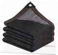 Stacked black shade netting panels with brown binding and top grommet corner tabs