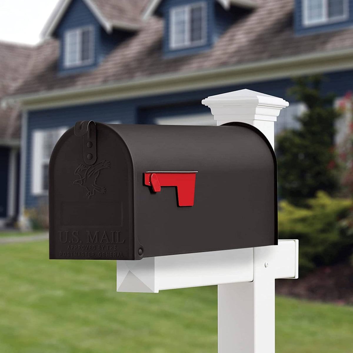 Black metal mailbox with red mail slot flap on white post