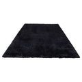 Black plush indoor area rug with shaggy low-pile texture, flat woven appearance