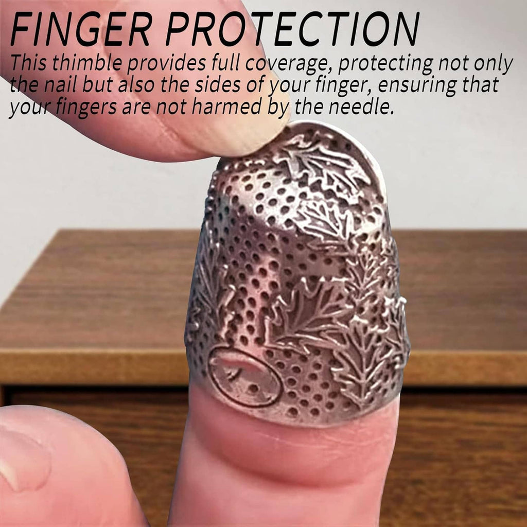 Metal finger thimble on fingertip with acorn motif and textured leaf engraving