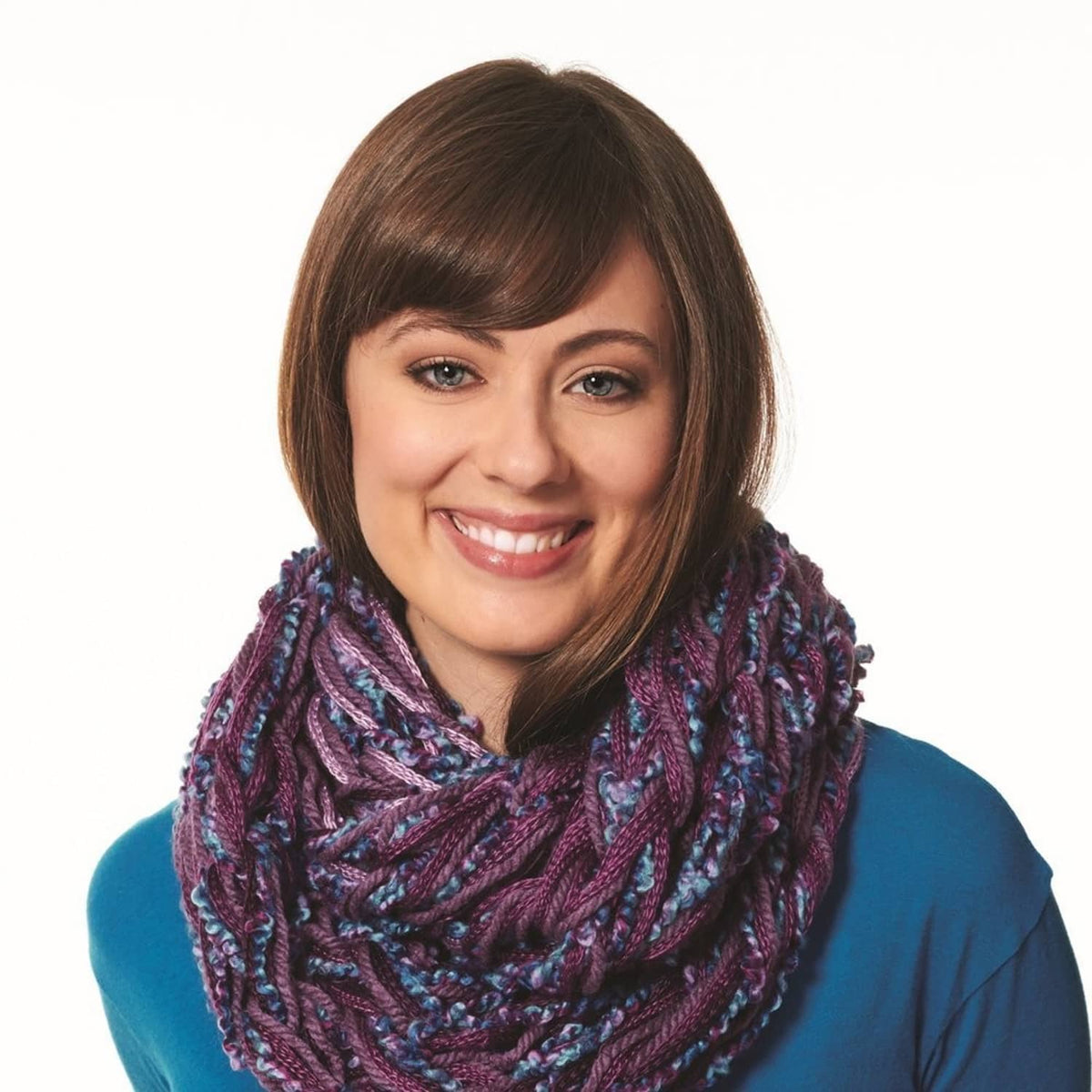 Chunky knit scarf in dark mauve with blue accents on a smiling model