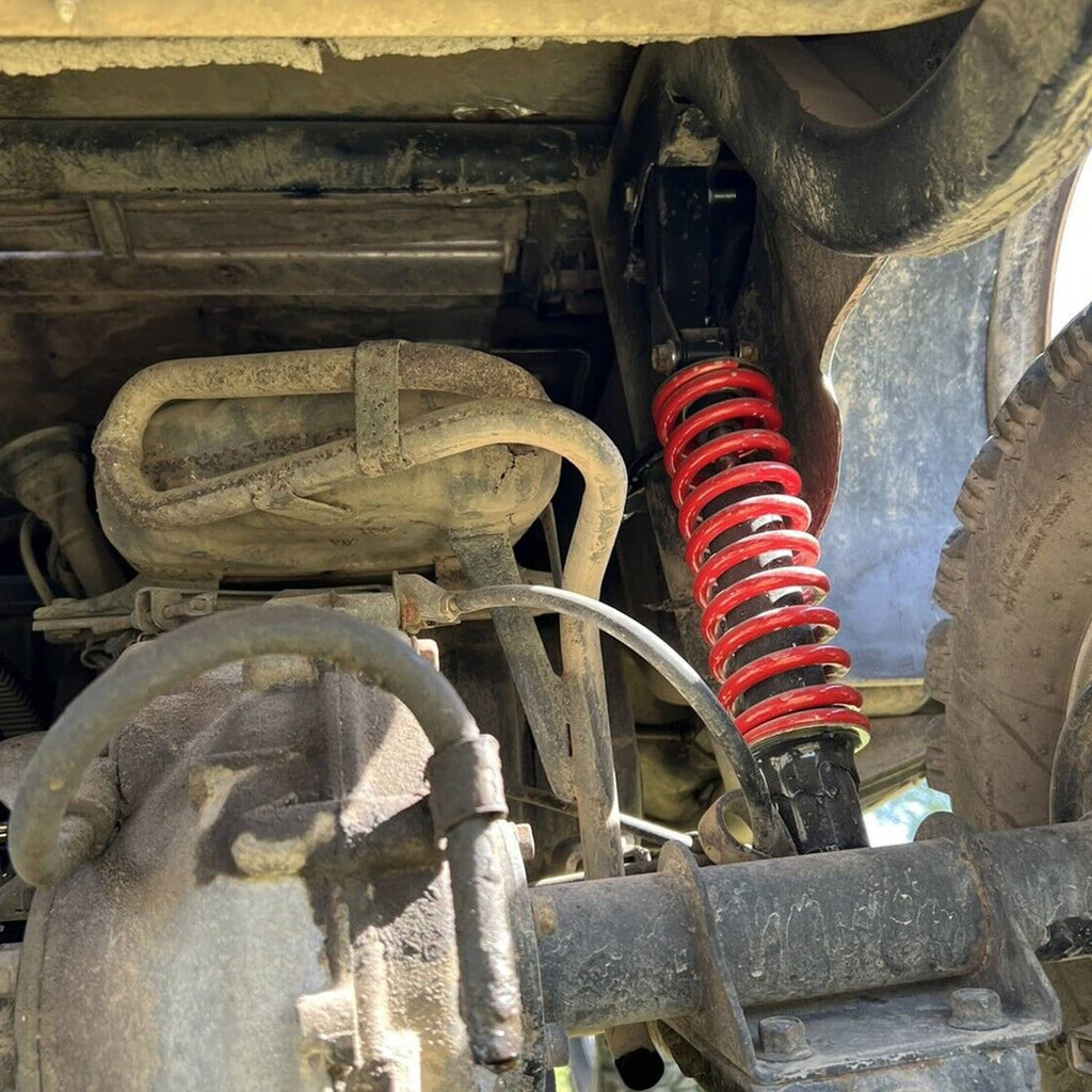 Close-up of suspension lift with red coil spring and installed A-arm components
