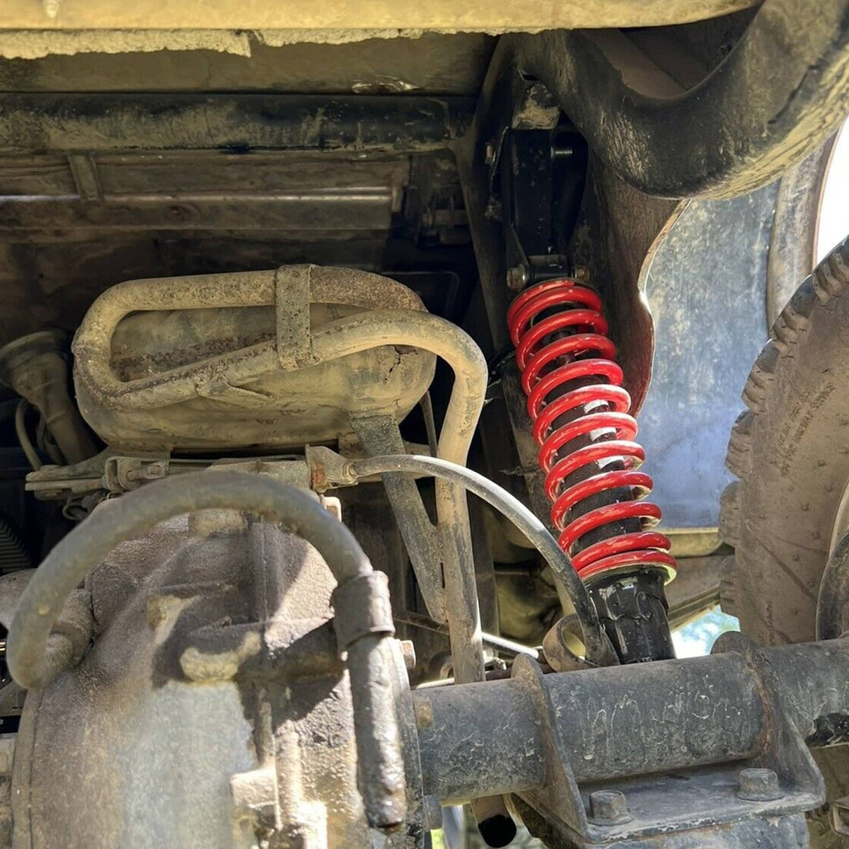 Close-up of suspension lift with red coil spring and installed A-arm components