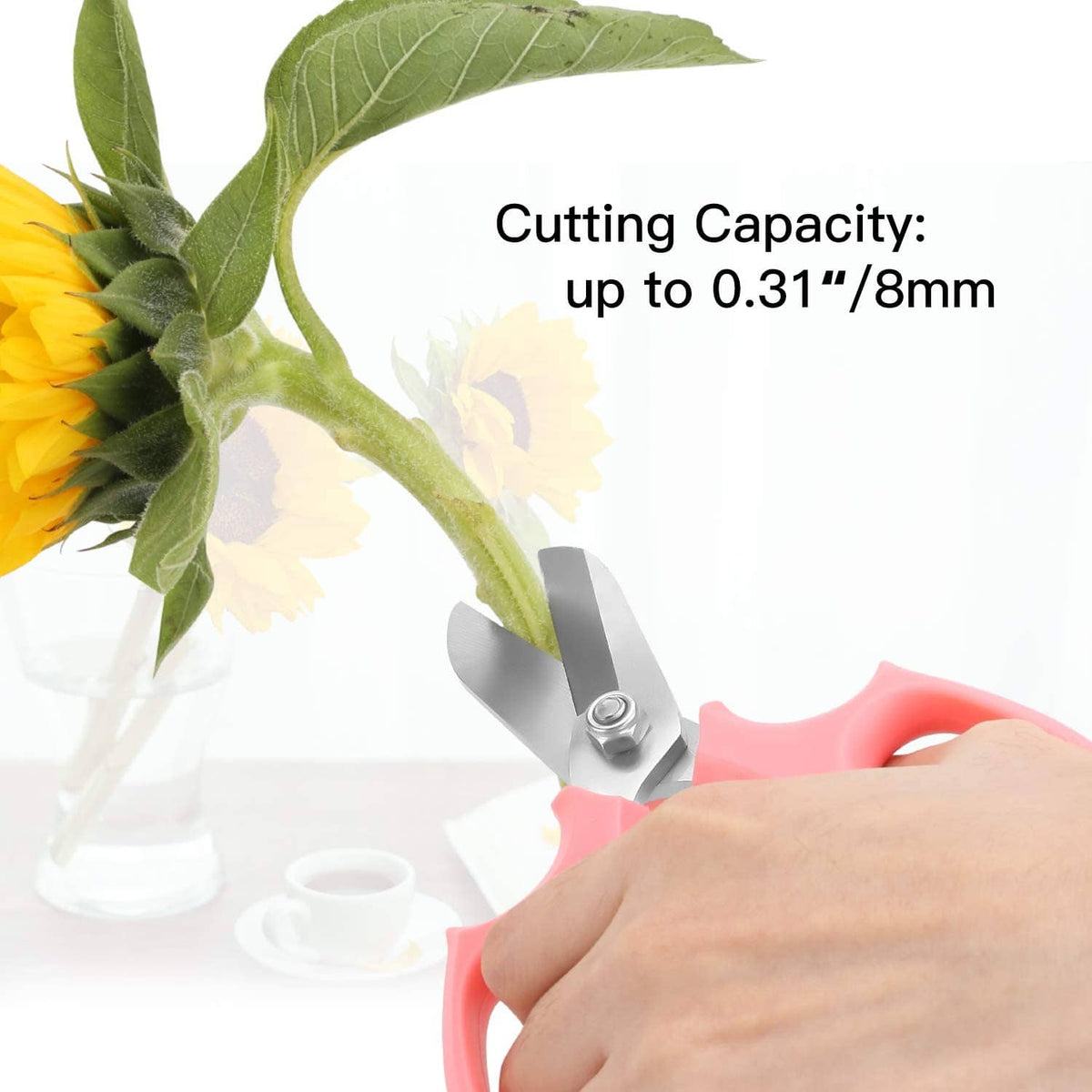 Pink pruning shears held in hand with silver blades