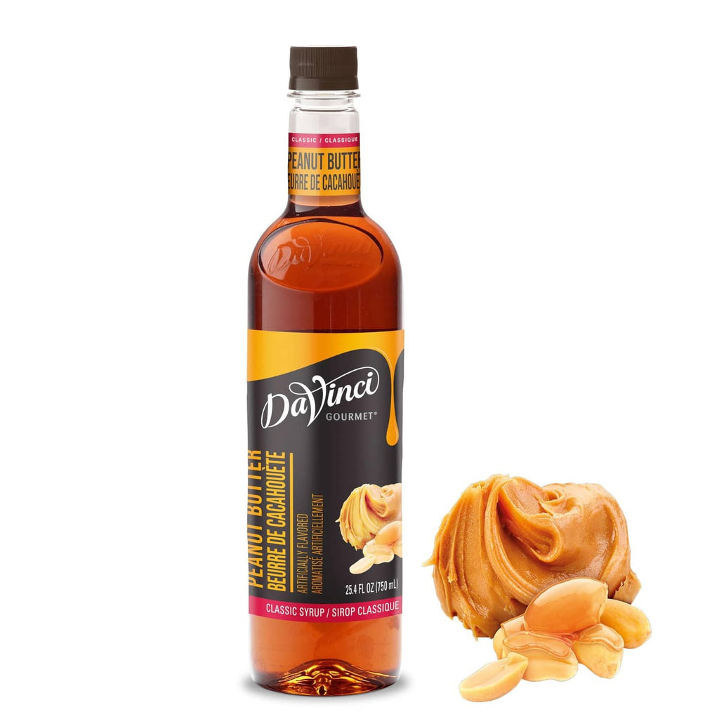 Peanut butter syrup bottle with label, plus peanut slices and creamy swirl