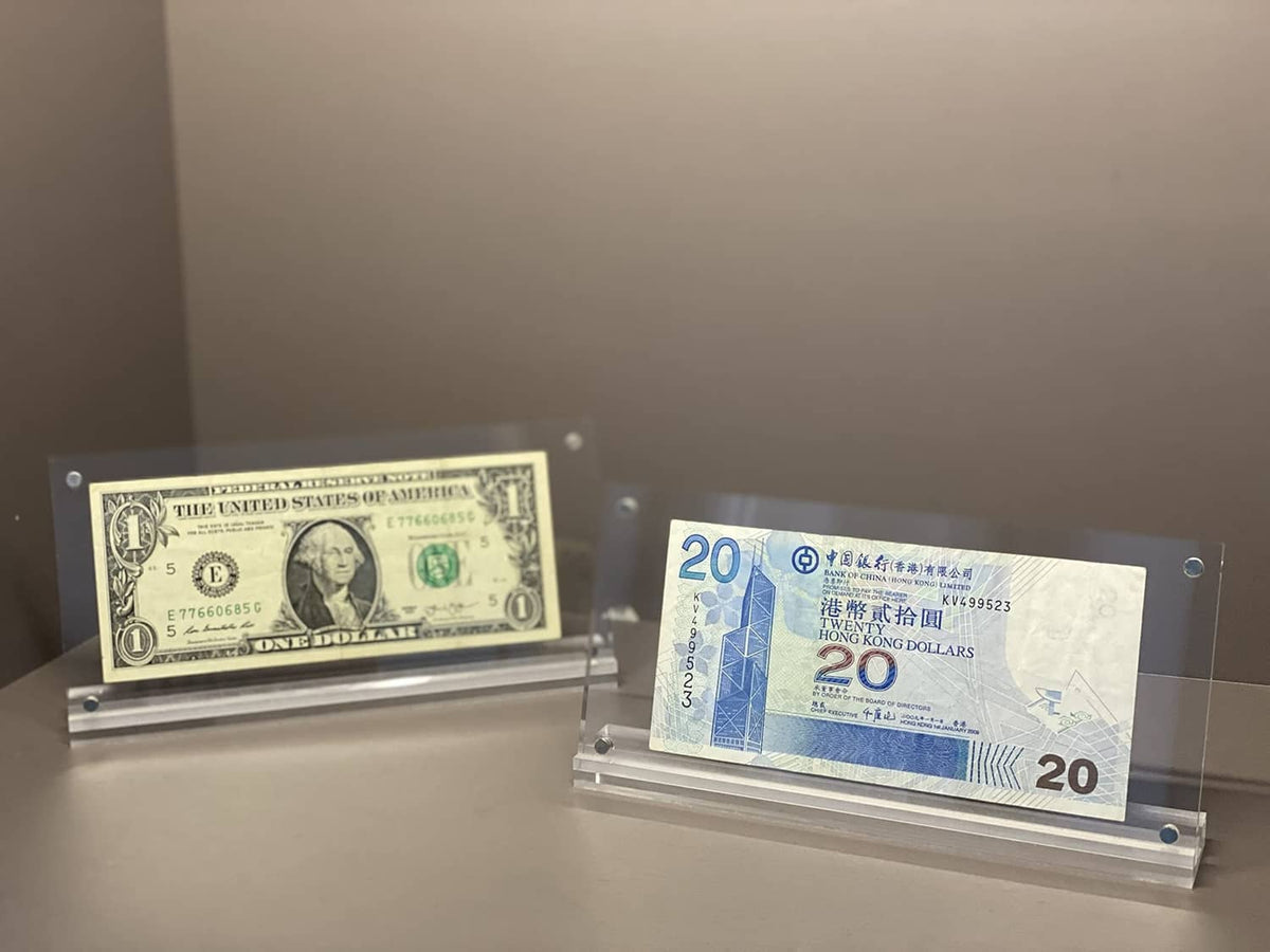 Clear acrylic display cases holding a $1 bill and a blue 20 note
