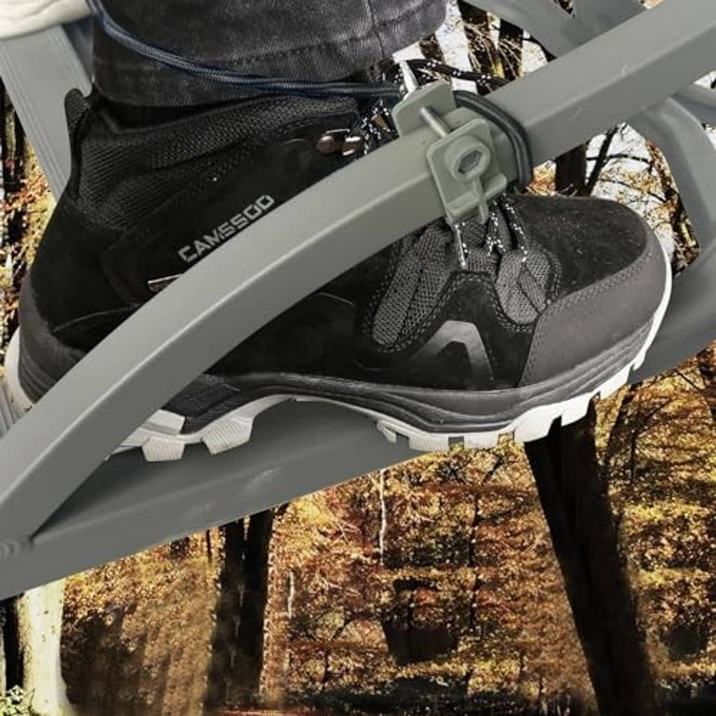 Black boot on gray climbing stirrup attached to tree stand ladder rail