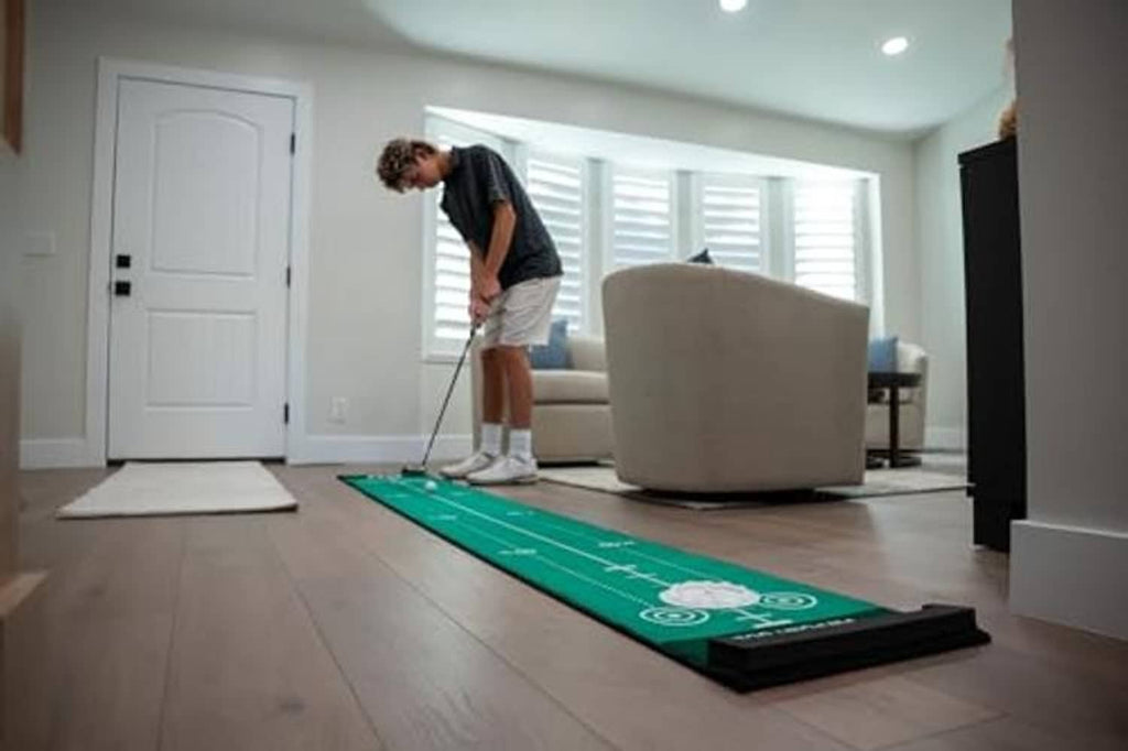 Green putting mat on floor with distance guides for indoor putting practice