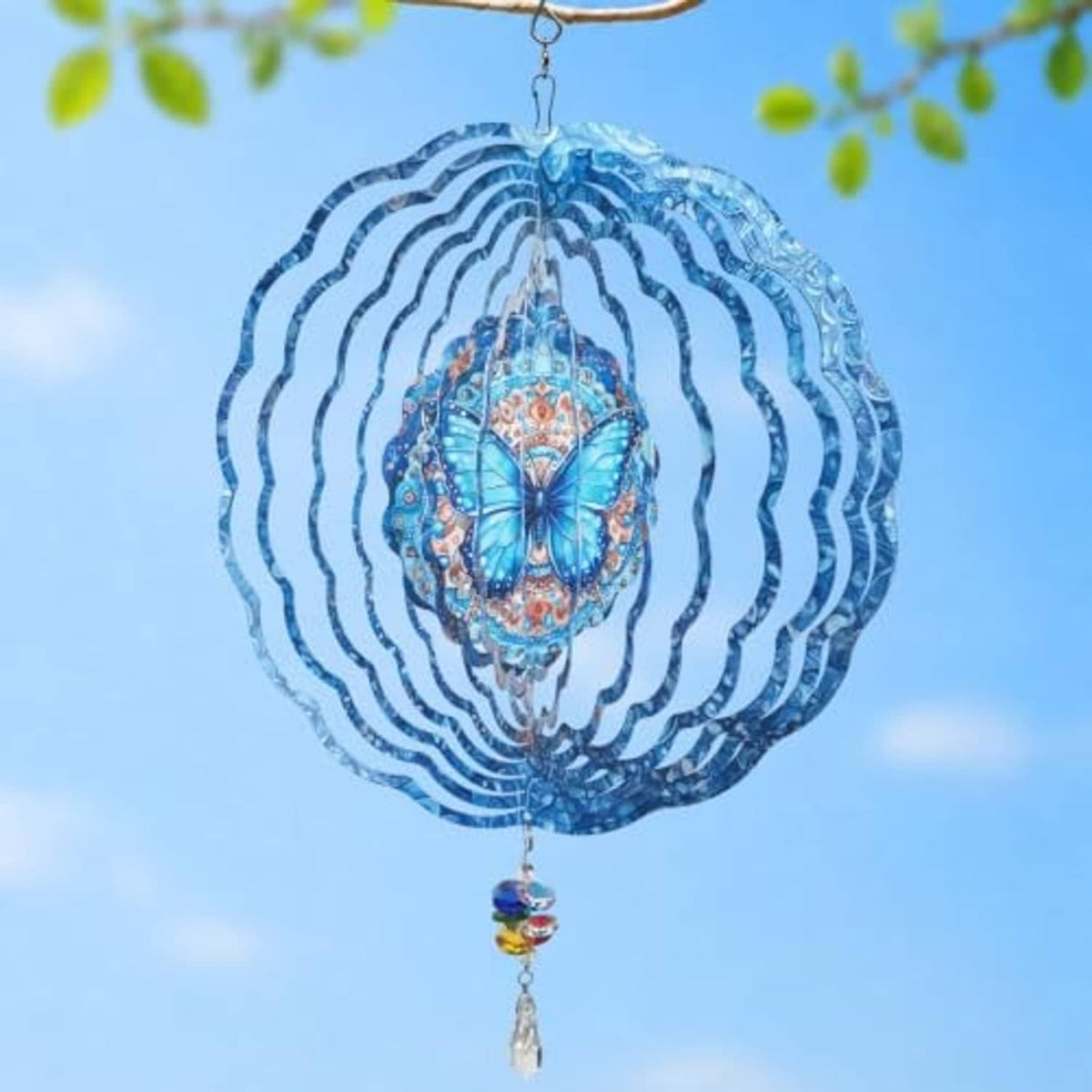 Blue butterfly wind spinner showing layered wavy rings and rainbow crystal charm