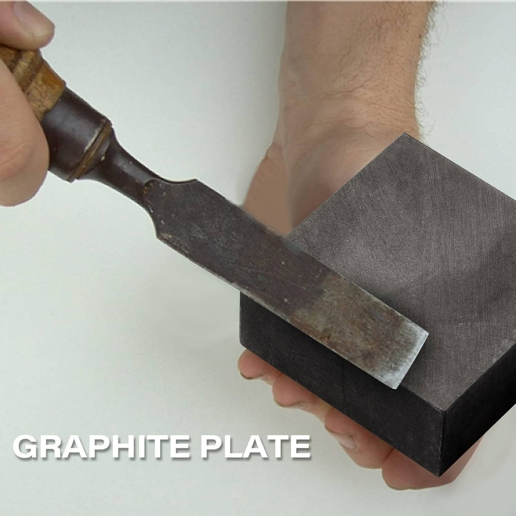 Graphite ingot block, dark gray rectangular prism held near a chisel tool
