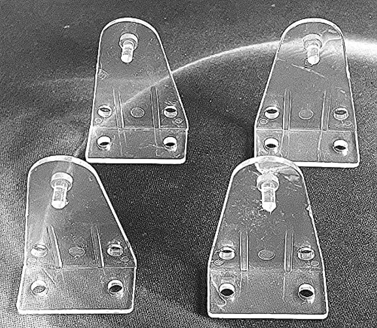 Clear hold-down brackets set with screw posts on metal base plates