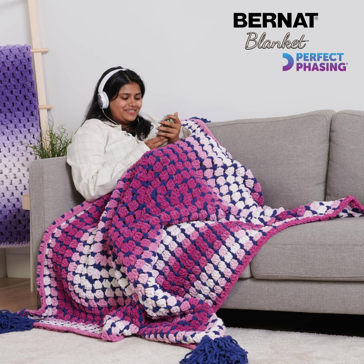 Crocheted gradient throw blanket in pink, purple, white, and blue with fringe