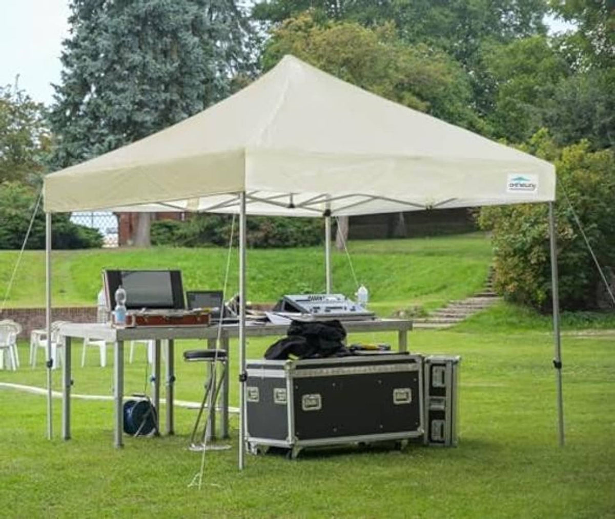 Beige canopy top on pop-up tent frame above outdoor dining table
