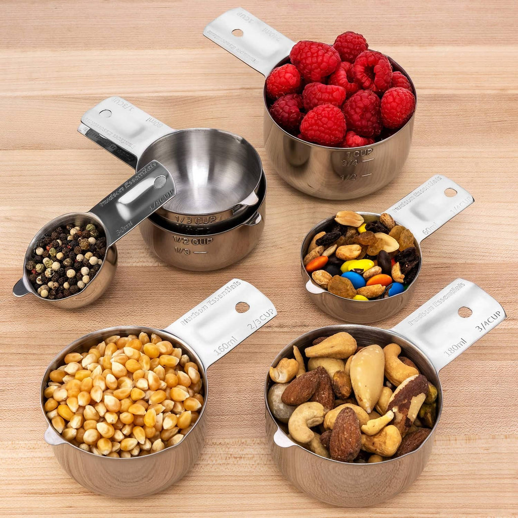 6-piece stainless steel measuring cup set with ingredients on a wooden board