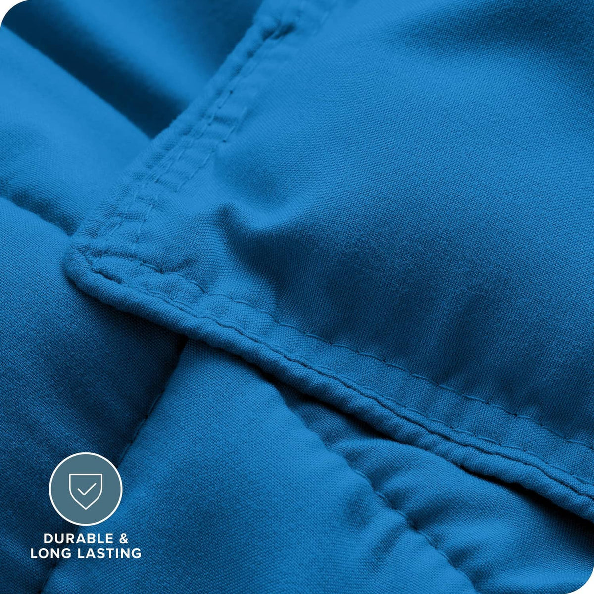 Blue comforter fabric close-up showing stitched seam and durable weave