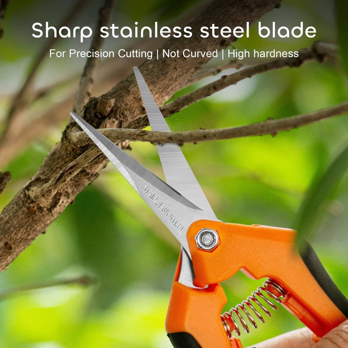 Orange pruning shears cutting on a wooden branch, stainless steel blade visible