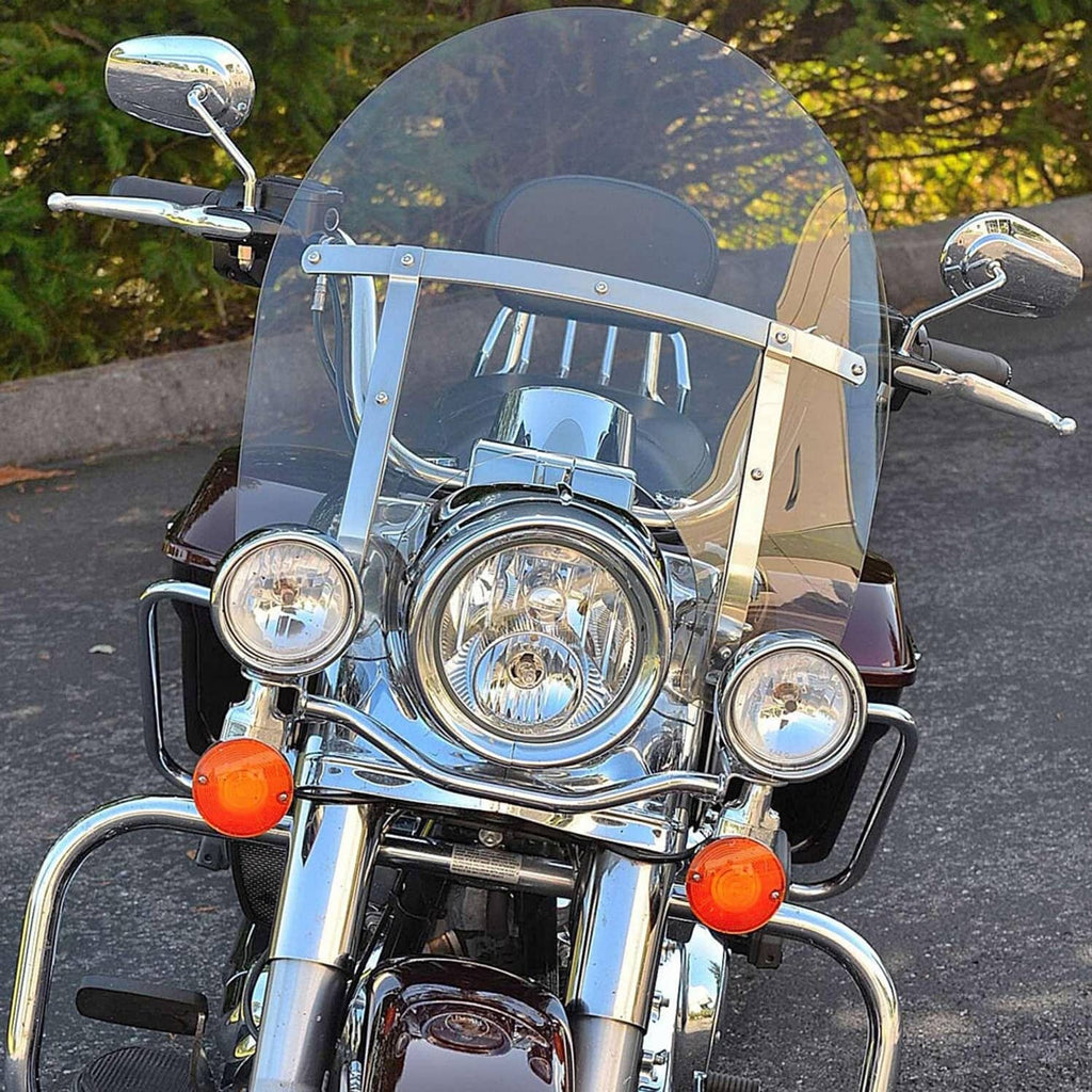 Clear motorcycle windshield with chrome mounting bracket on handlebars