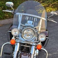 Clear motorcycle windshield with chrome mounting bracket on handlebars