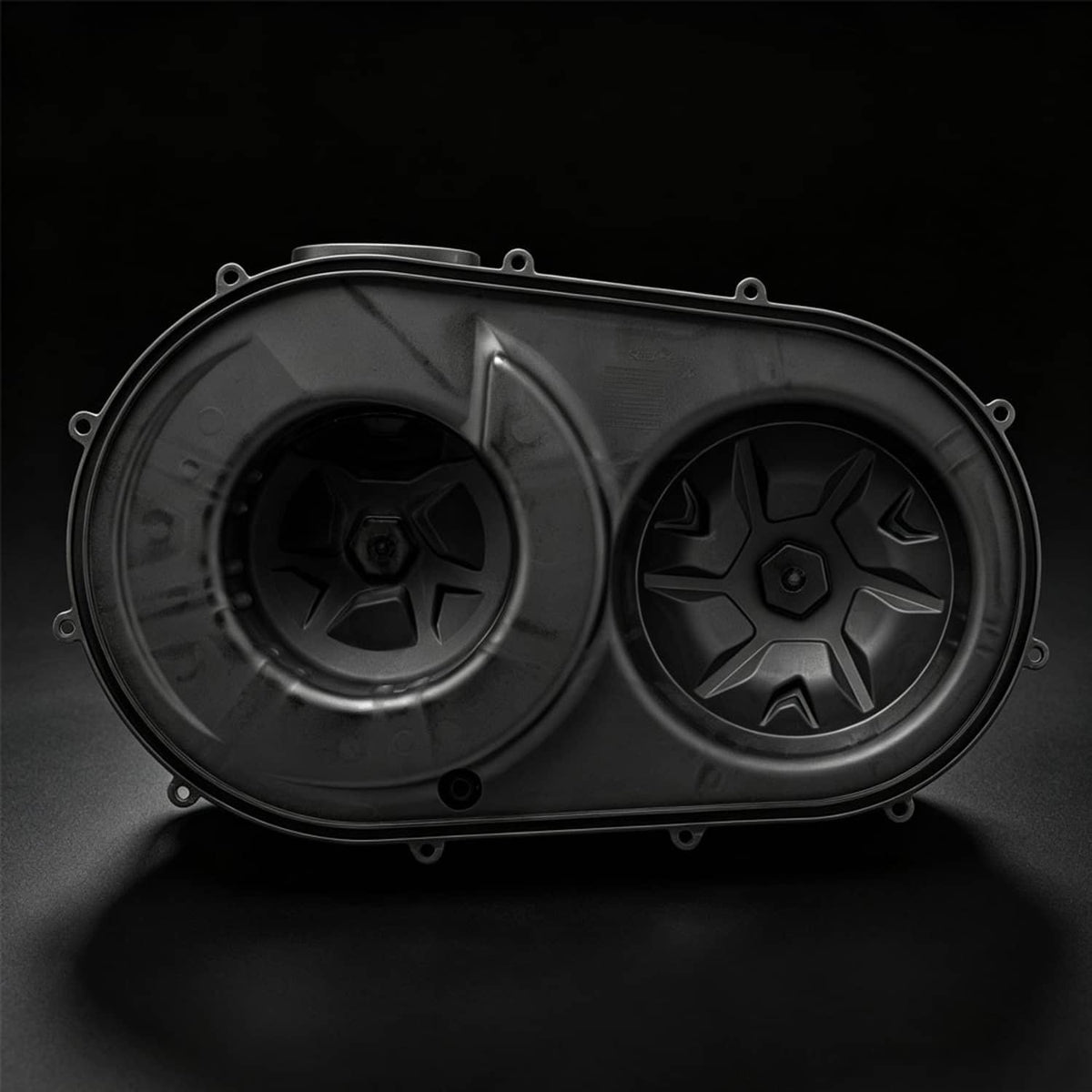 Dark outer clutch cover with two circular openings and star-pattern inserts