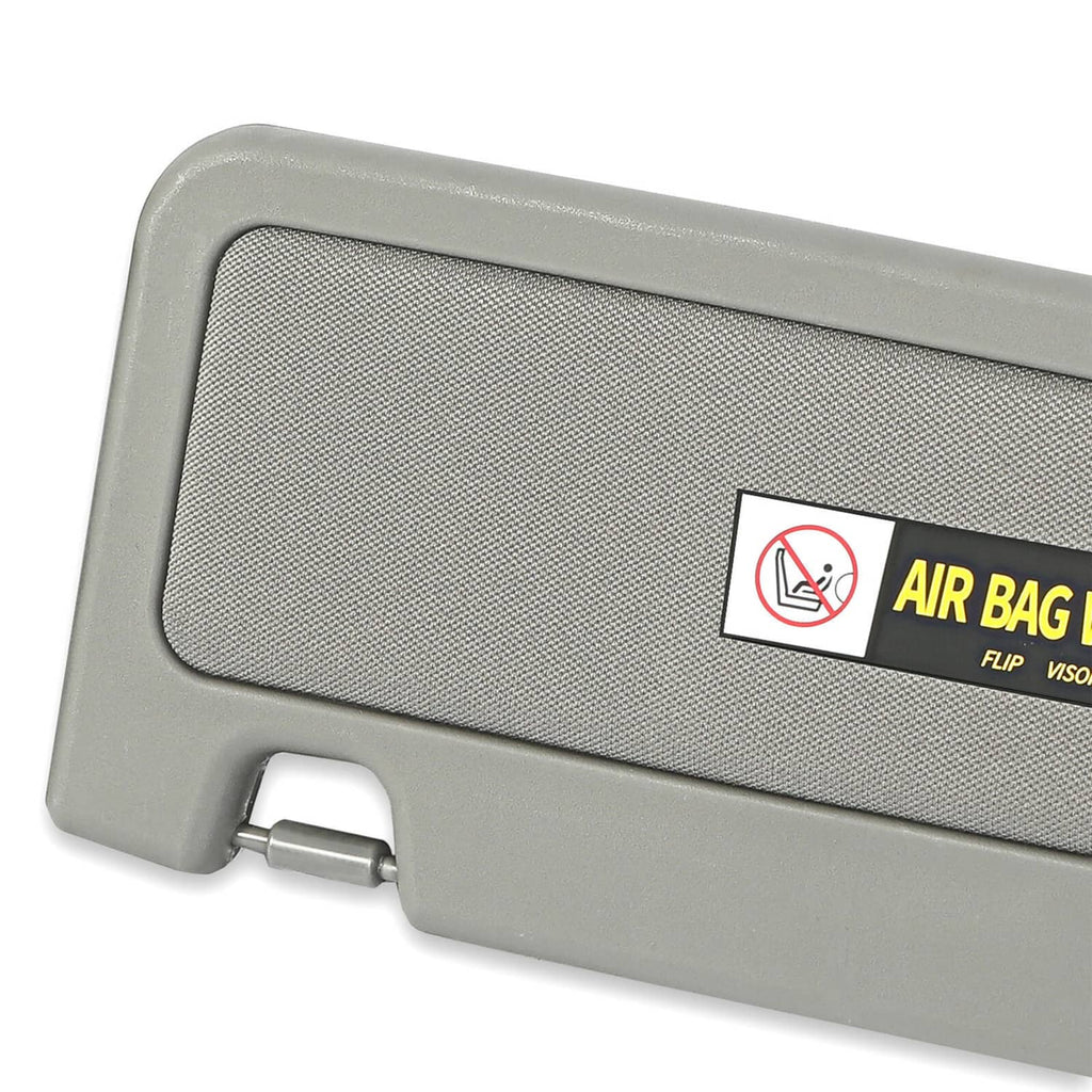 Grey sun visor with textured cover and air bag warning sticker