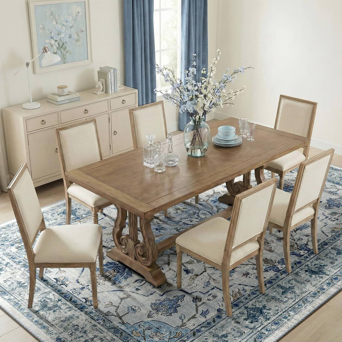 Blue/white/gray area rug with ornate border pattern under dining set