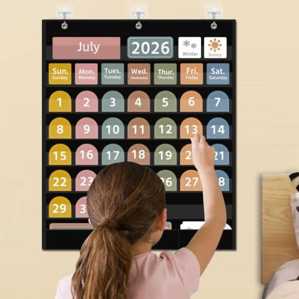 Black calendar pocket chart mounted on wall with July 2026 and day/date cards