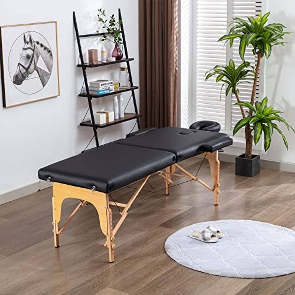 Black padded massage table with wooden folding legs and cushioned headrest
