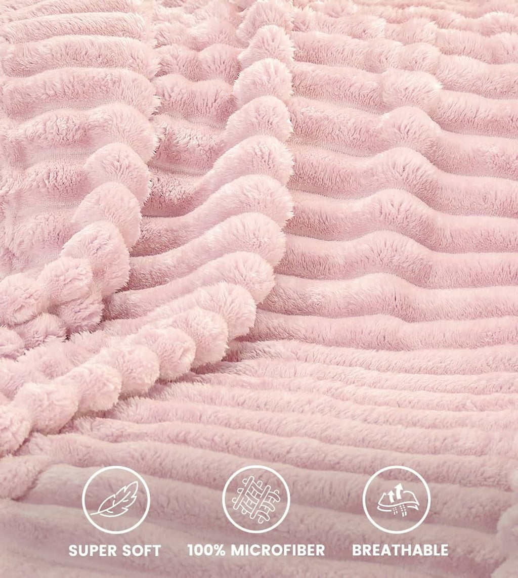 Pink plush fleece blanket with raised stripe texture, close-up