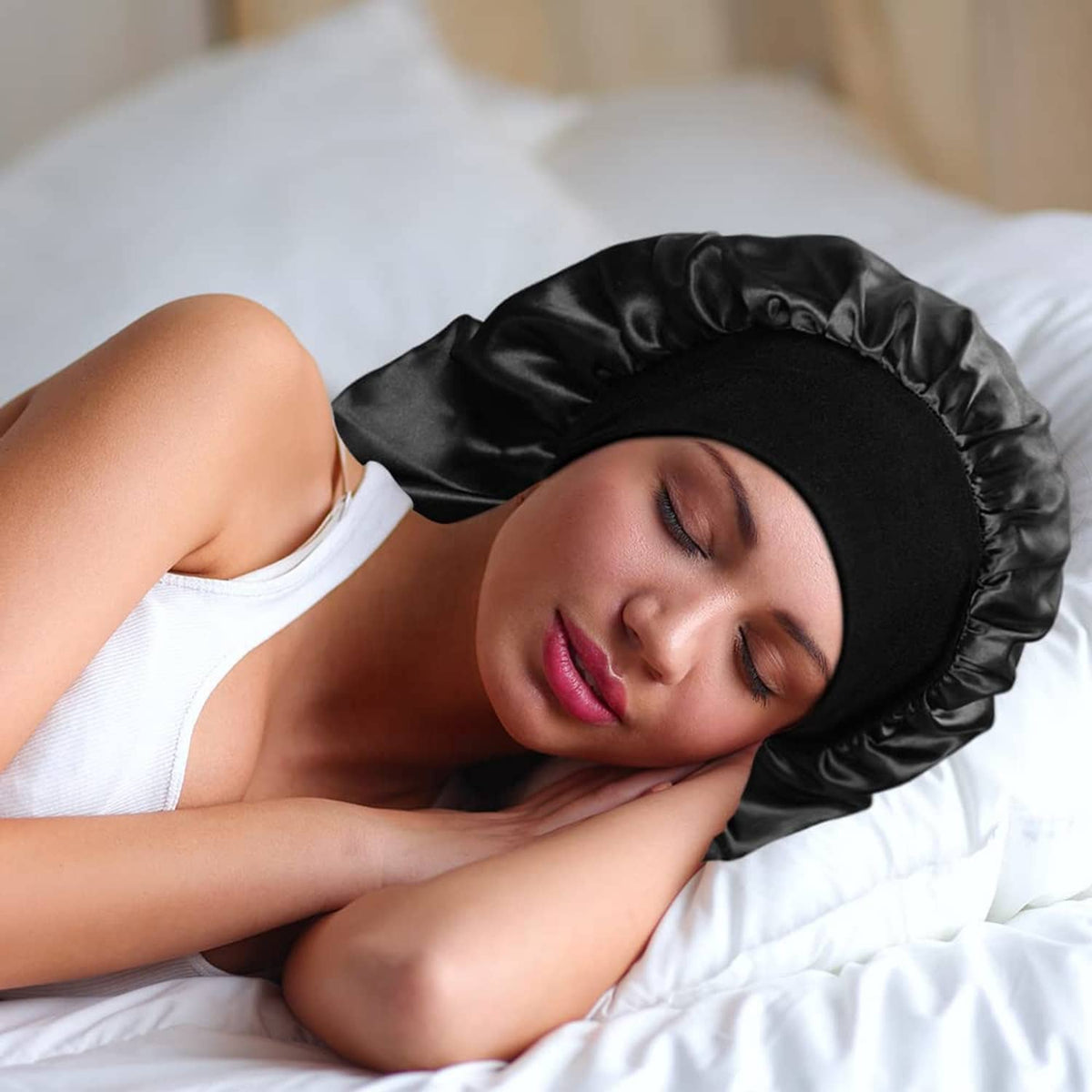 Black satin sleep bonnet with ruffled trim, worn on head while lying on bed