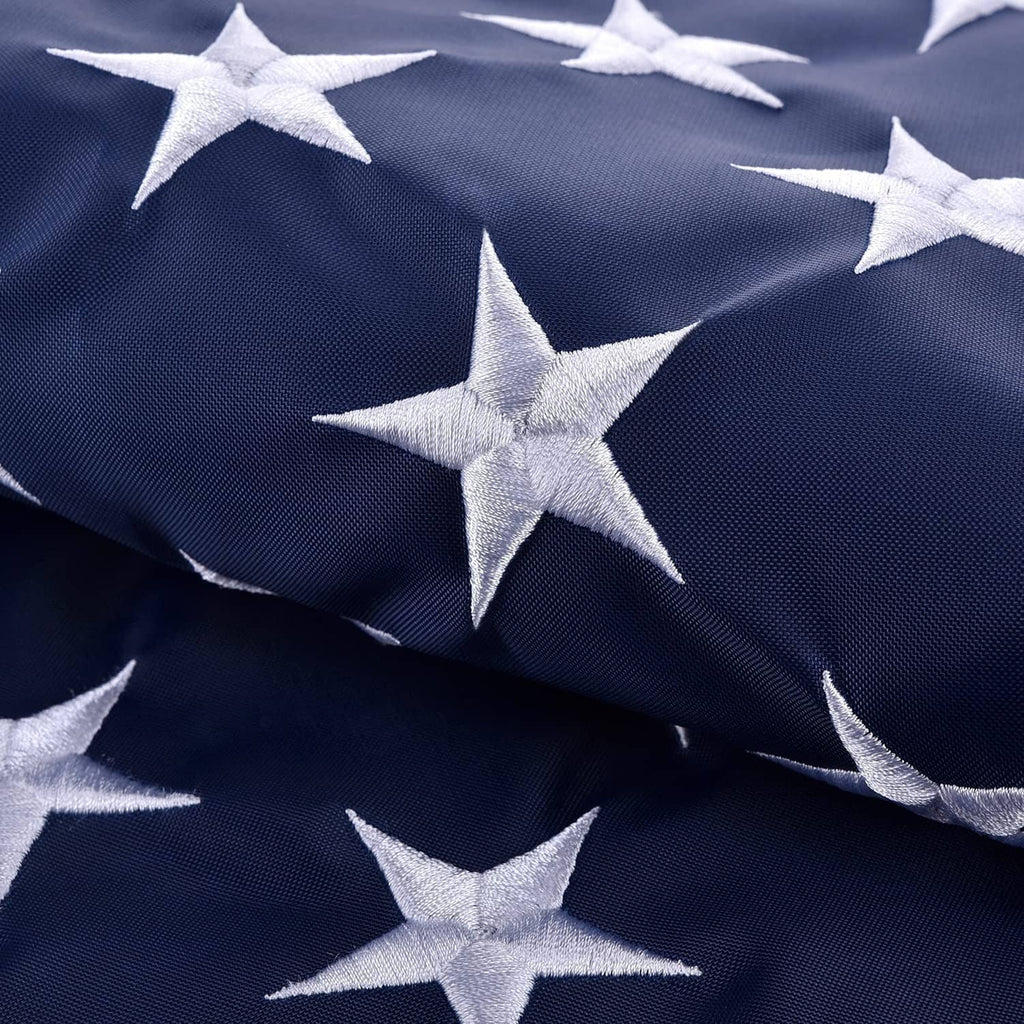 Close-up of US flag blue fabric with raised white stars, folded drape texture.