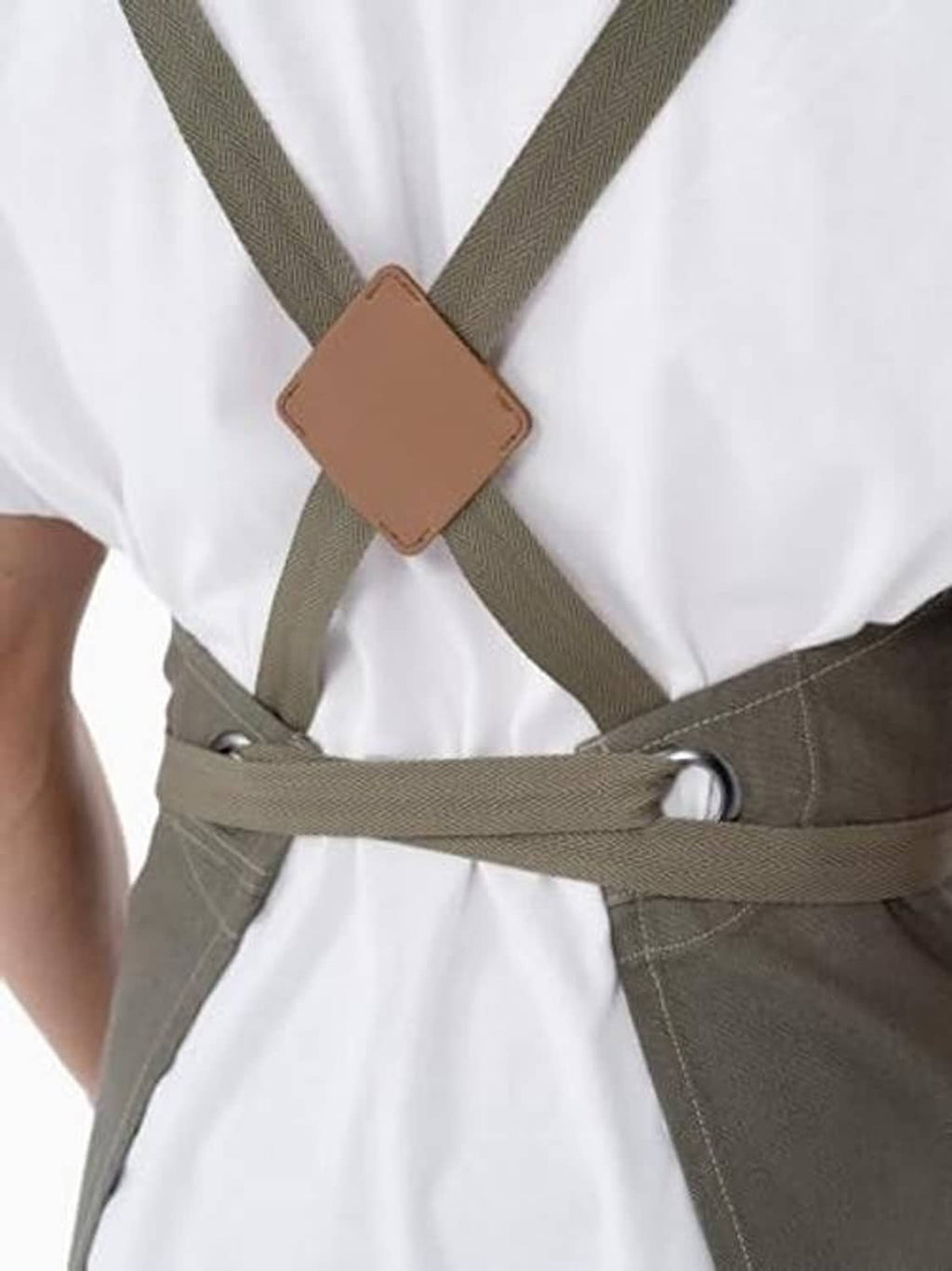 Olive apron close-up: tan neck straps with brown leather-style connector patch