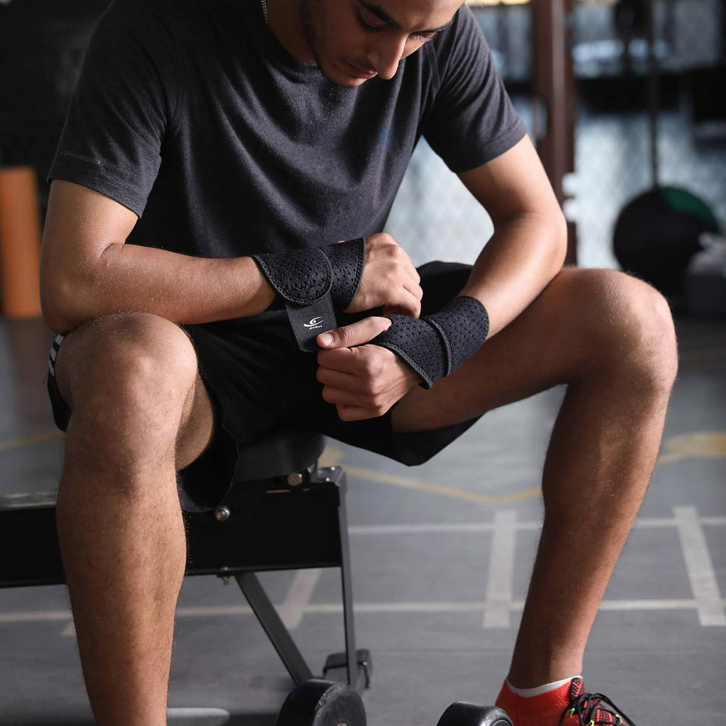 Black wrist compression strap on a seated athlete’s wrist, adjustable band