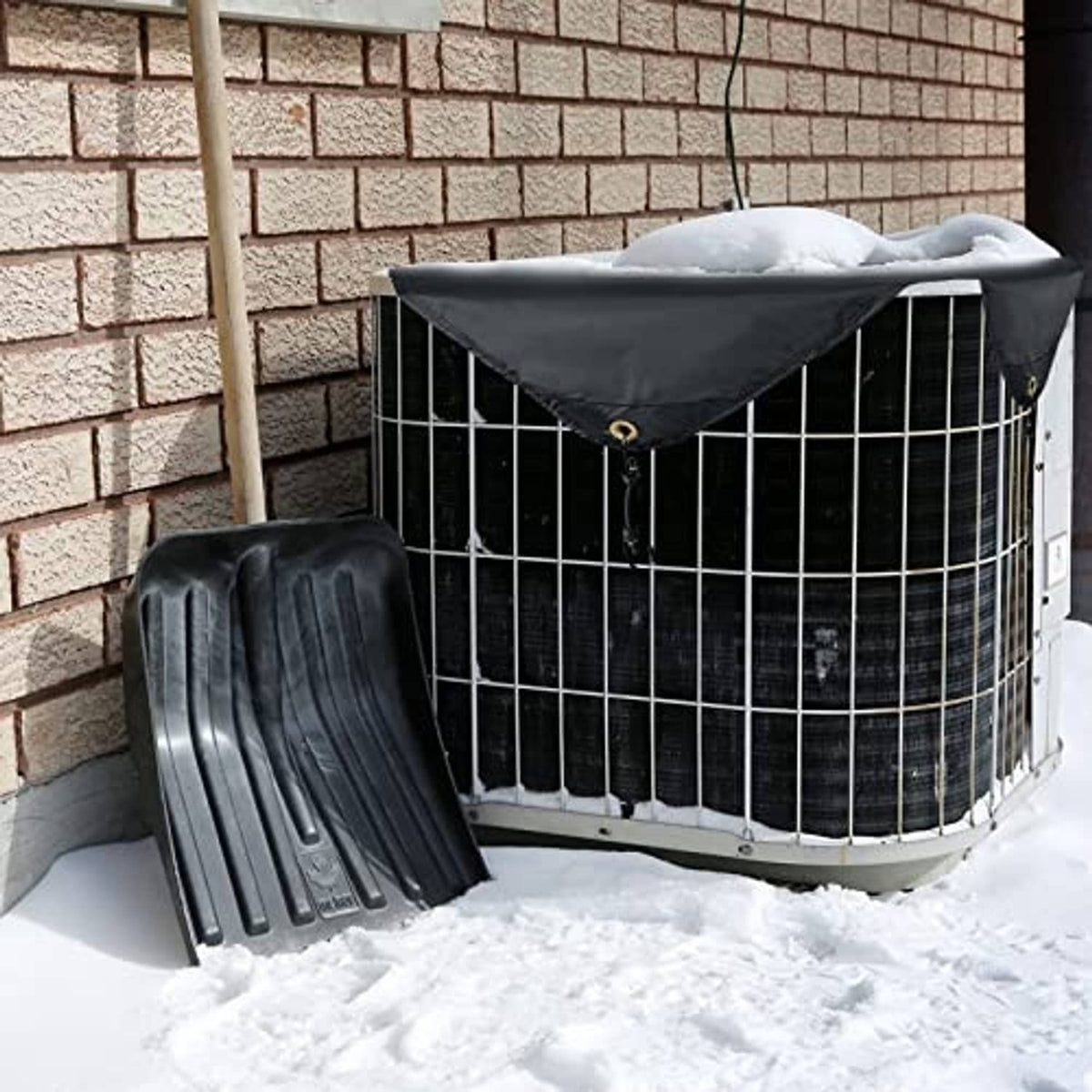 Black fitted outdoor AC cover on condenser unit, secured with bungee straps