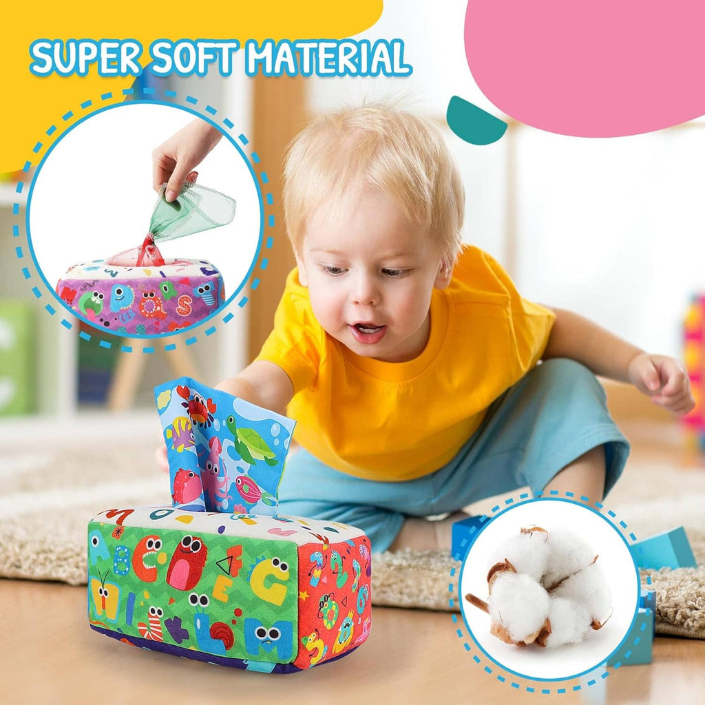 Colorful crinkle tissue box toy on play area with baby reaching toward it