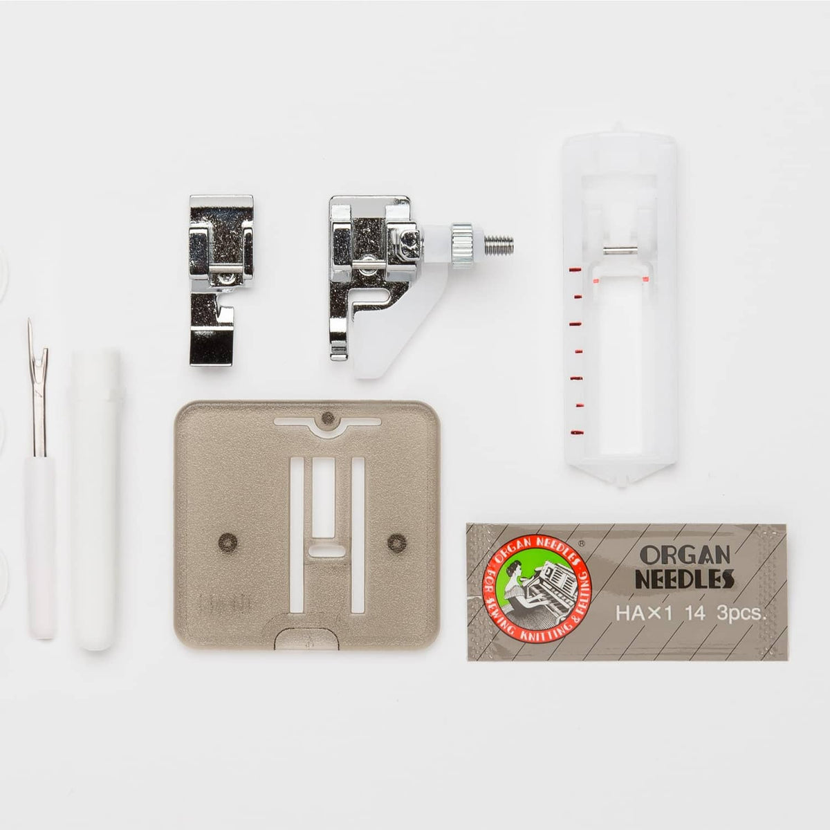 Sewing machine accessory set with presser feet, needle pack, and plastic tool