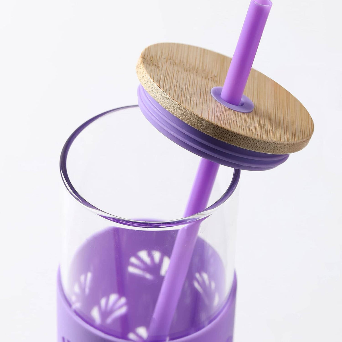 Close-up of purple silicone-sleeved glass tumbler with bamboo lid and upright straw