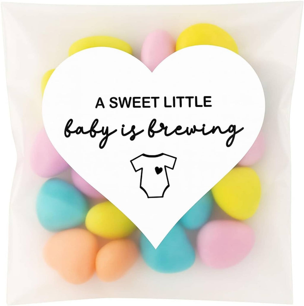 Heart-shaped sticker with “A SWEET LITTLE baby is brewing” wording and baby onesie