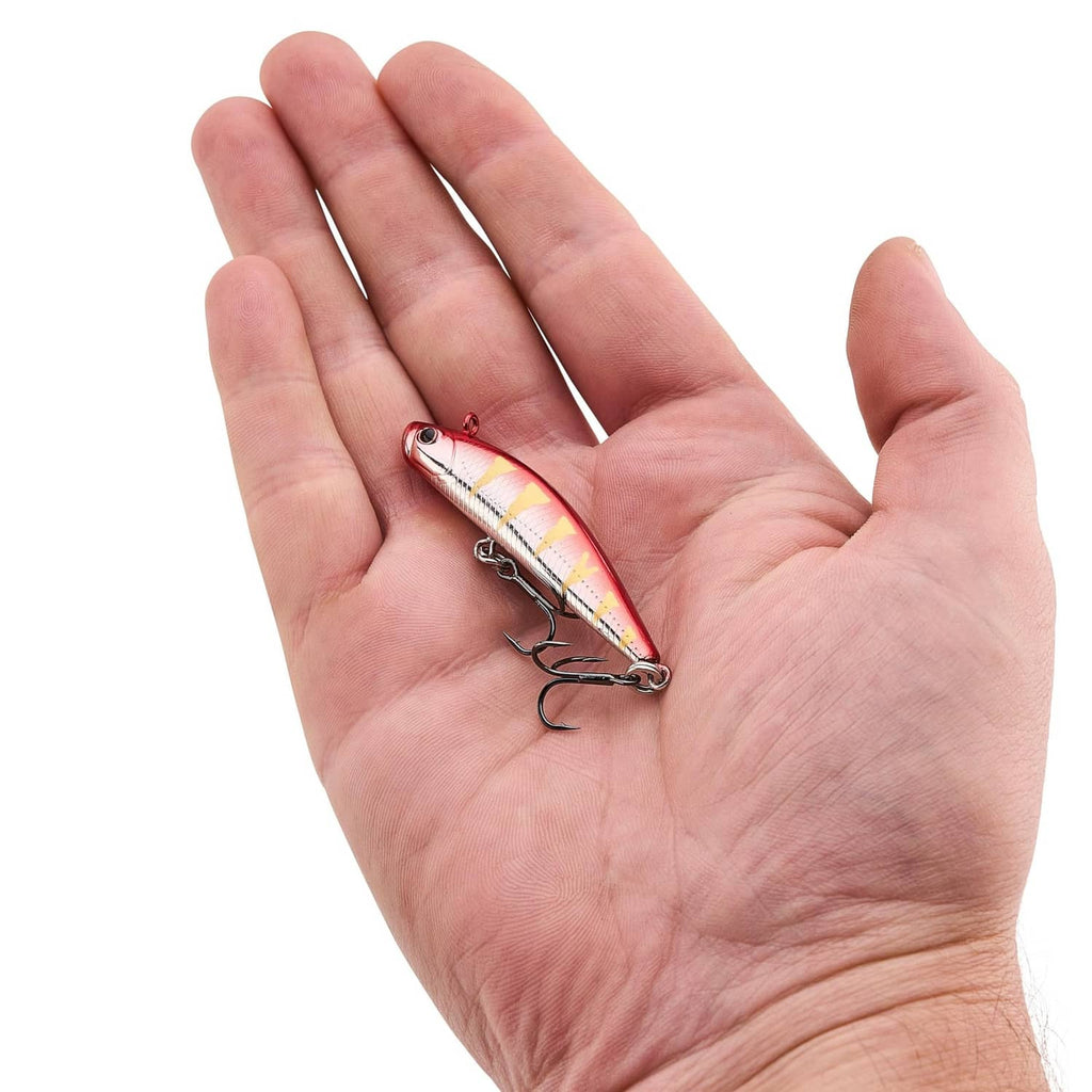 Fishing lure held in a hand, red-silver body with treble hooks.