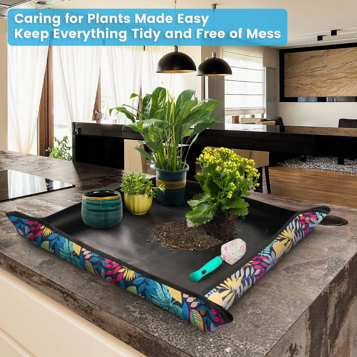 Black plant repotting tray with colorful leaf print border and gardening tools on top