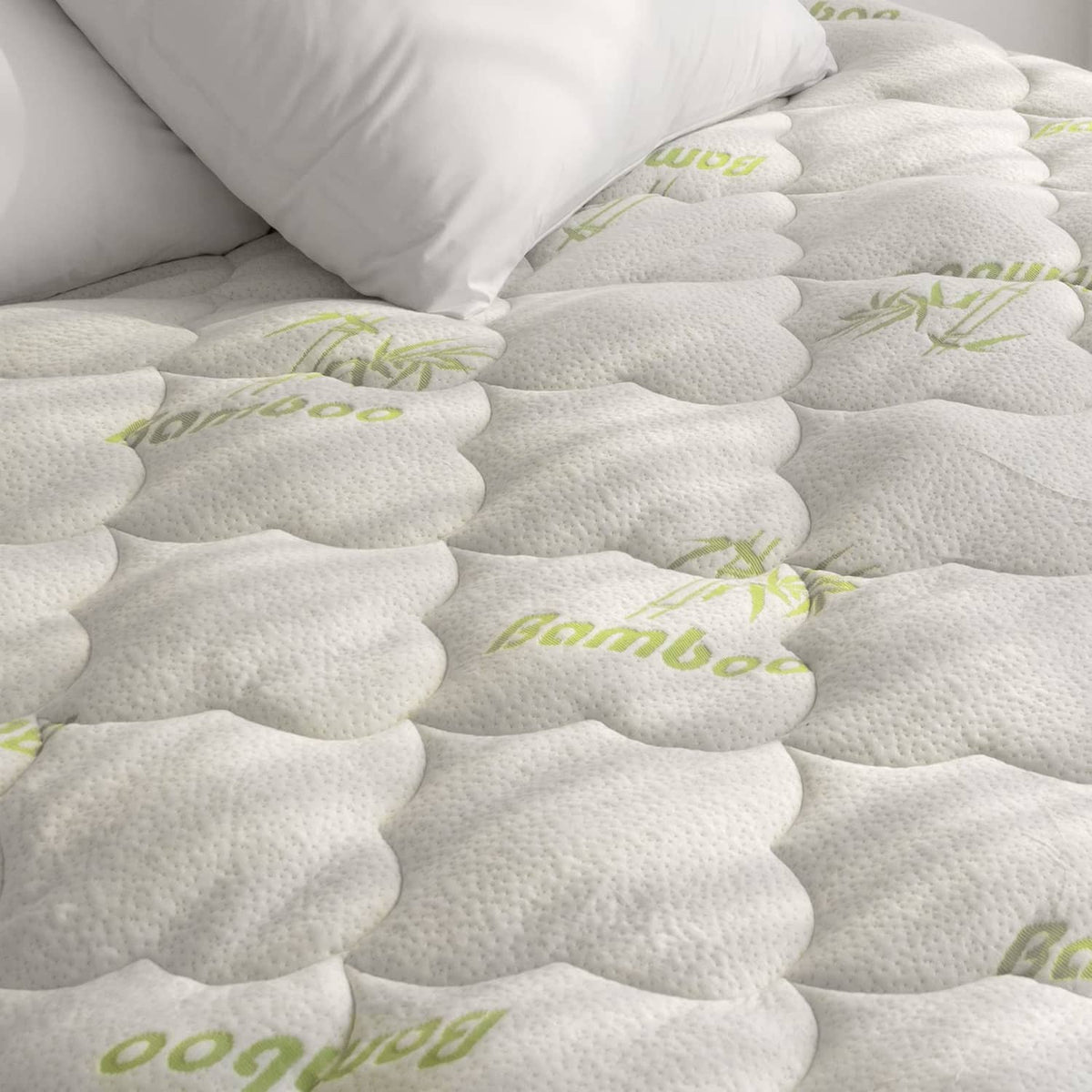 White quilted mattress pad cover with green bamboo print, scalloped texture top