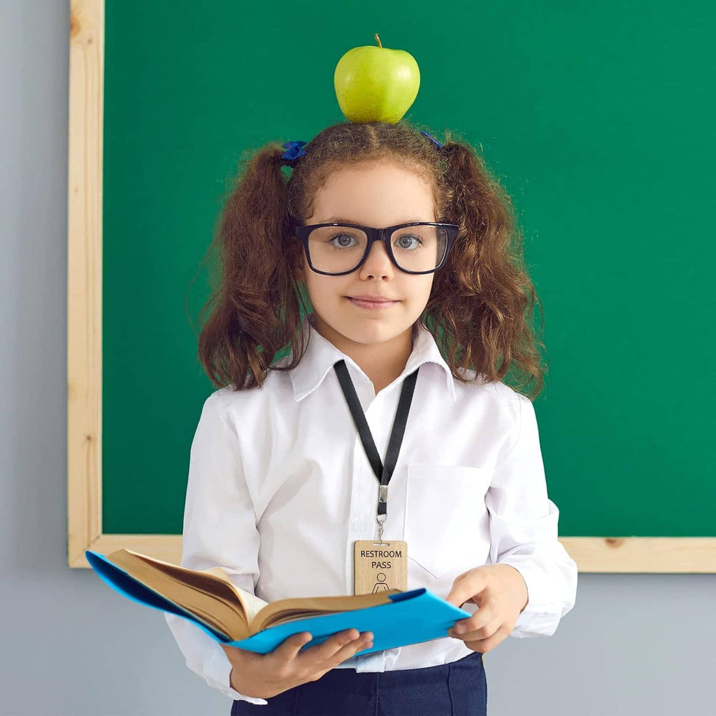 Child holding bathroom pass card on black lanyard, school pass set