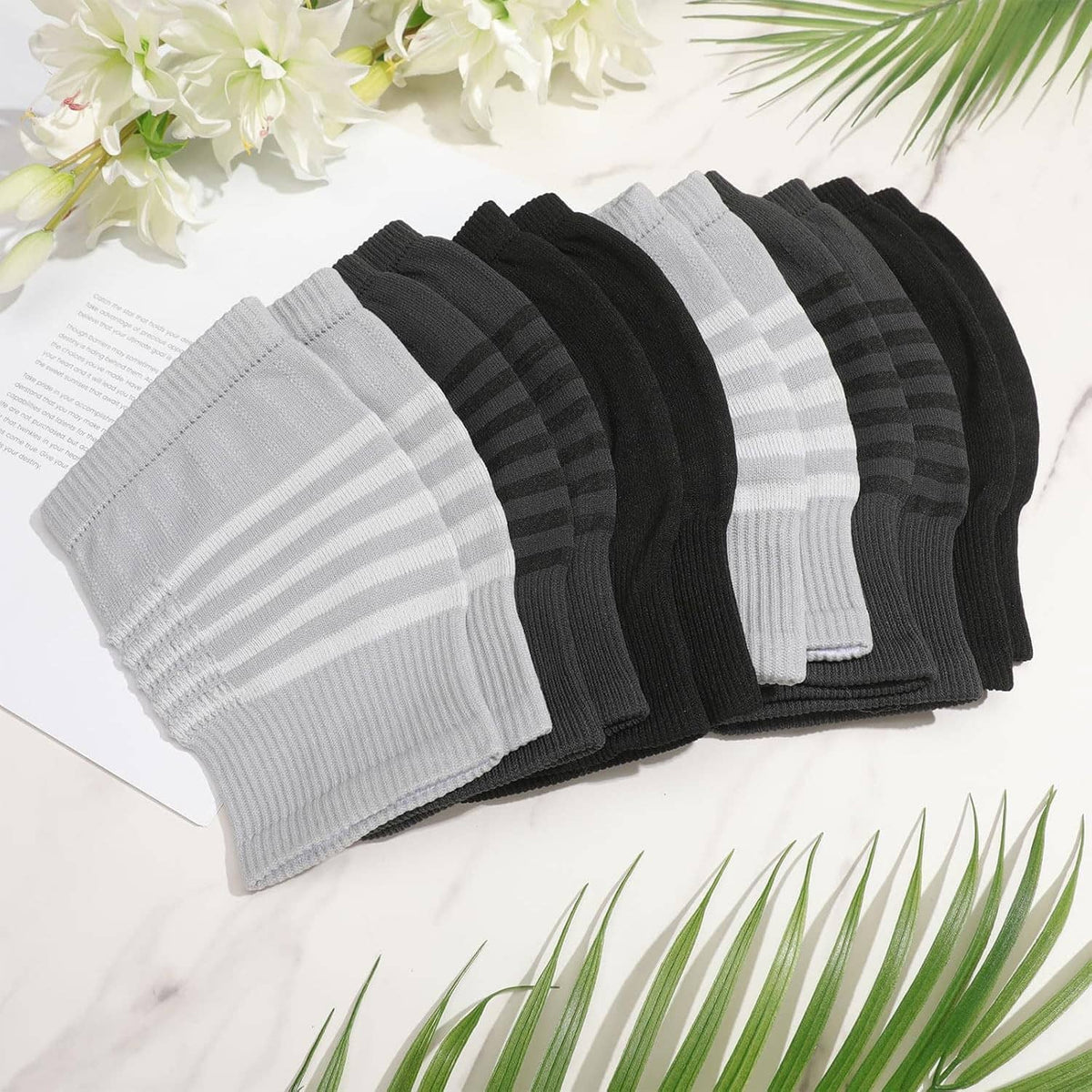 Knee warmers 6-pack with striped ribbed knit in white, gray, and black tones.