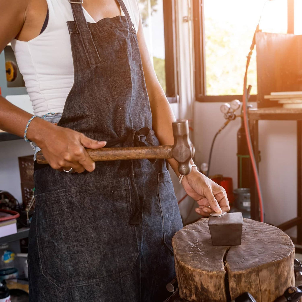 Round steel bench block in use with hammer, silver metal mallet tool