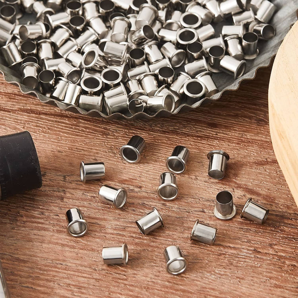 Silver shelf pin sleeves scattered on wood, compact metal cabinet shelf supports.
