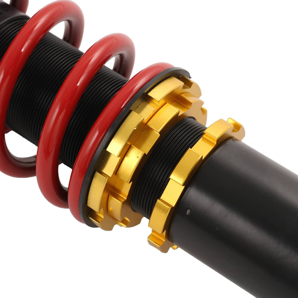 Close-up coilover strut: red spring with gold adjuster rings and black damper