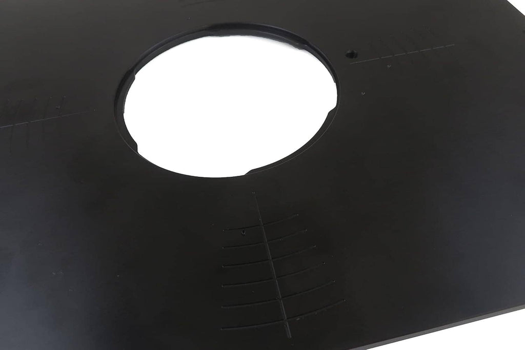 Close-up of black router table insert plate showing the large circular opening and measurement marks.