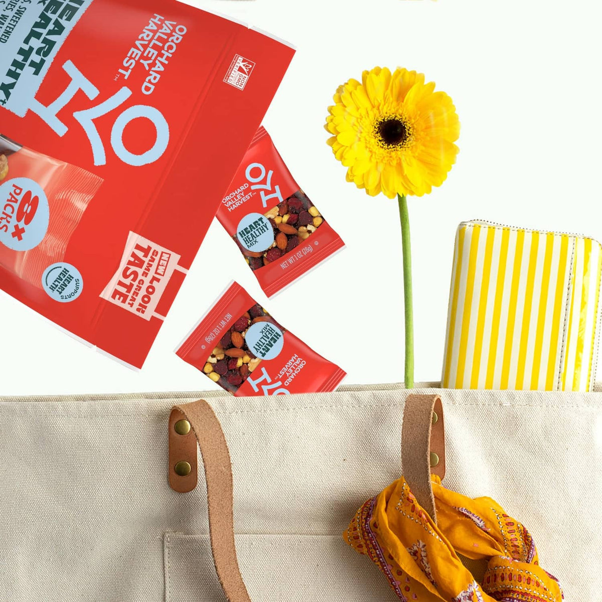 Red Orchard Valley Harvest Heart Healthy Mix pouches beside a canvas bag and flower
