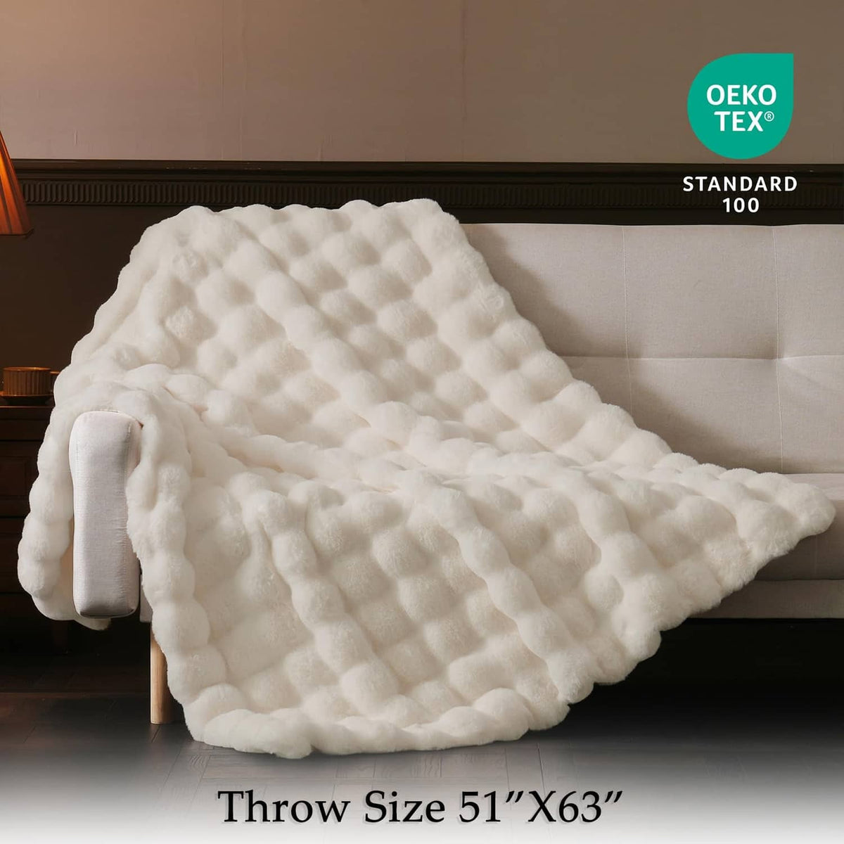 Cream faux fur throw blanket with oversized bubble texture, folded on a chair