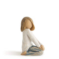 Seated child figurine with brown hair, white robe, and blue-gray blanket, kneeling.