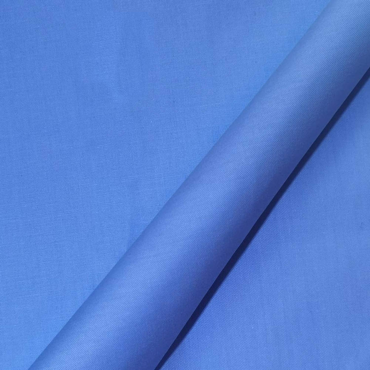 Close-up of smooth solid blue cotton fabric with subtle woven texture